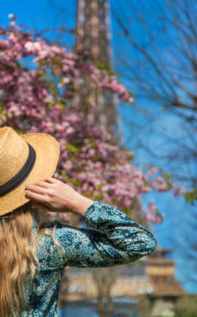 A woman in a hat looks at the Eiffel Tower. Selective focus.の写真素材