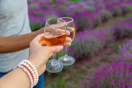 A woman and a man drink wine in a lavender field. selective focus. food.の写真素材