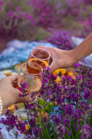 A woman and a man drink wine in a lavender field. selective focus. food.の写真素材