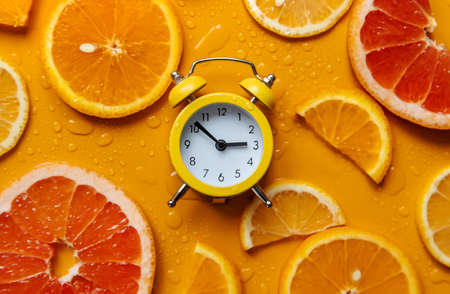 Clock and citruses summer time concept. selective focus. food.