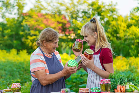Women with jar preserved vegetables for the winter mother and daughter. selective focus. food.の写真素材