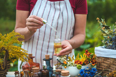 Woman with medicinal herbs and tinctures. selective focus. Nature.の写真素材
