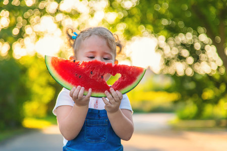 Child girl eats watermelon in summer. selective focus. food.の写真素材