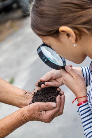 The child examines the soil with a magnifying glass. selective focus. kid.の写真素材