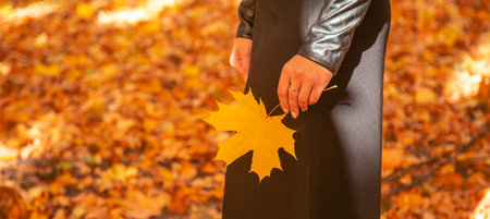 Woman with autumn leaves in her hand. Selective focus.の写真素材
