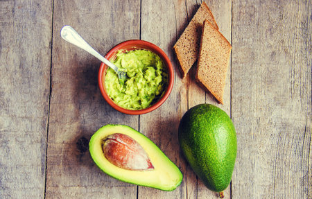 Traditional Hispanic Mexican sauce guacamole and avocado sandwiches on a wooden background. Selective focus.の写真素材