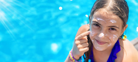 Child near the pool smears sunscreen. selection focus. kid.
