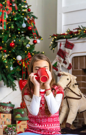 Children drink tea near the Christmas tree. selective focus. kid.の写真素材