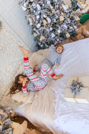Children jump on the bed near the Christmas tree. selective focus. kid.の写真素材