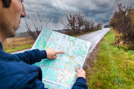 A man looks at a map on the road. selective focus. people.