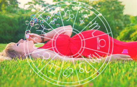 A pregnant woman blows soap bubbles. selective focus.の写真素材