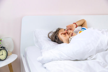 The child sleeps in the morning in bed. selective focus. kid.の写真素材