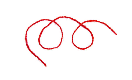 Red thread isolate on white background. Selective focus.の写真素材