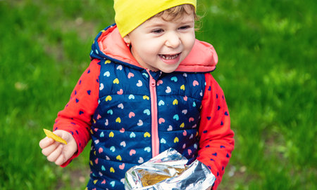 The child eats chips in the park. selective focus. Nature.