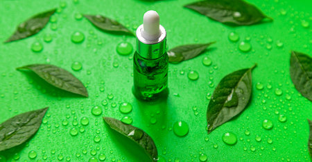 Drops of oil pipette on green leaves background. selective focus. Nature.の写真素材