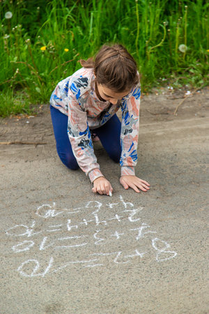 Children draw equations on the pavement with chalk. selective focus. kid.の写真素材