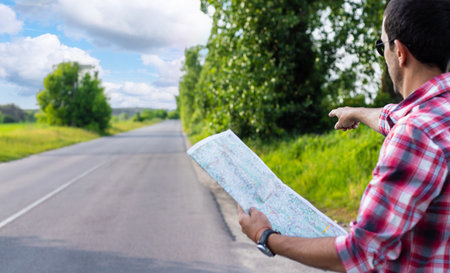 A man on the road is looking at a map. selective focus. Nature.の写真素材