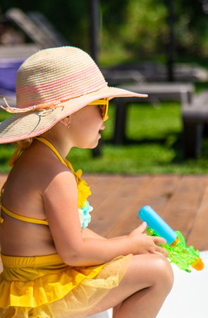 A child plays in the pool with a water gun. selective focus. kid.の写真素材