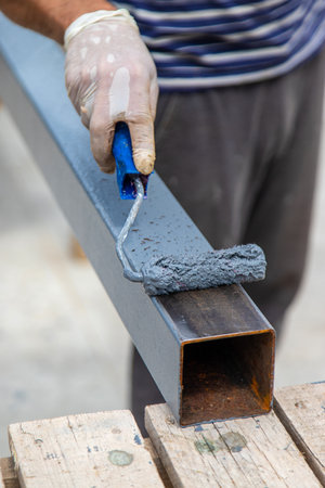 A man paints a metal pole. selective focus. Nature.の写真素材