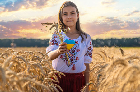 Child in a field of wheat with the flag of Ukraine. selective focus. Nature.の写真素材