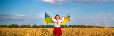 Child in a field of wheat with the flag of Ukraine. selective focus. kid.の写真素材