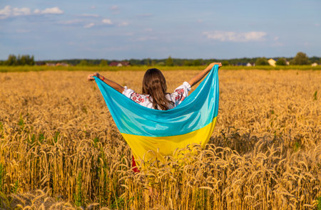Child in a field of wheat with the flag of Ukraine. selective focus. kid.の写真素材