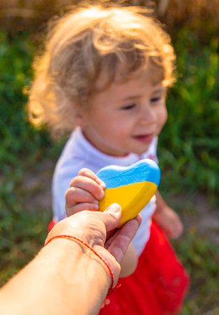 Child in a field of wheat with the flag of Ukraine. selective focus. Nature.の写真素材