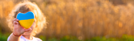 Child in a field of wheat with the flag of Ukraine. selective focus. Nature.の写真素材