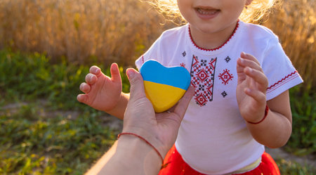 Child in a field of wheat with the flag of Ukraine. selective focus. Nature.の写真素材