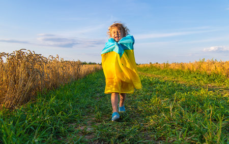 Child in a field of wheat with the flag of Ukraine. selective focus. kid.の写真素材