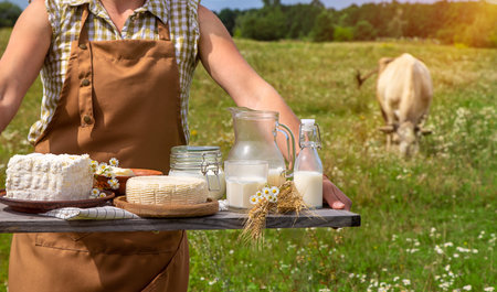 Dairy products on a cow farm are held by a woman in her hands. selective focus. food.