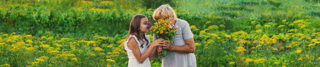 Grandmother and granddaughter hold medicinal herbs and flowers in their hands. Selective focus. Nature.の写真素材