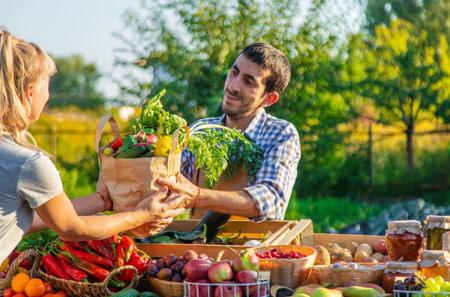 Man and woman at a farmers market. Selective focus. Food.の写真素材