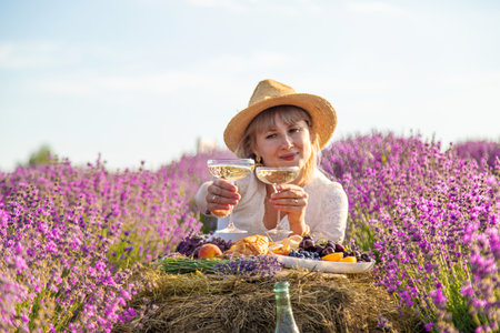 A woman drinks wine in a lavender field. Selective focus. Nature.の写真素材