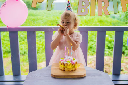 A three year old child blows candles on a cake. Selective focus. Kid.の写真素材