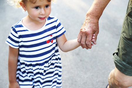 Child with grandmother holding hand. Selective focus. Nature.の写真素材