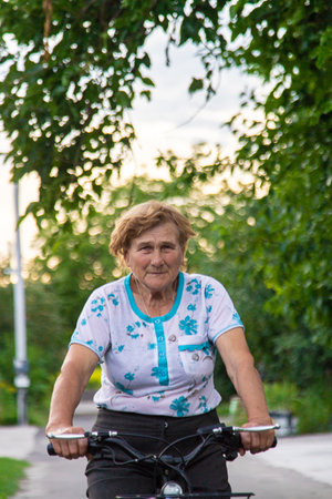 An elderly woman rides a bicycle. Selective focus. Nature.の写真素材