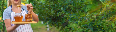 A woman holds honey in the garden. Selective focus. Nature.の写真素材