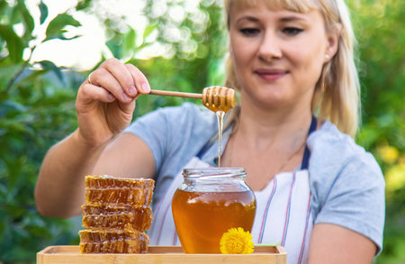 A woman holds honey in the garden. Selective focus. Nature.の写真素材