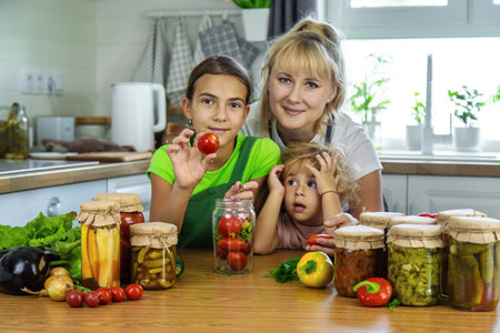 Family canning vegetables in jars in the kitchen. Selective focus. Food.の写真素材