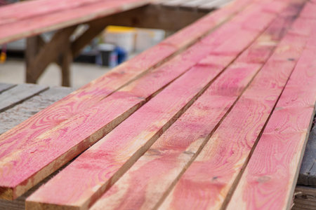 A man treats a board with a red antiseptic. selective focus. Nature.の写真素材