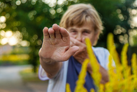 An elderly woman is allergic to ragweed. selective focus. Nature.