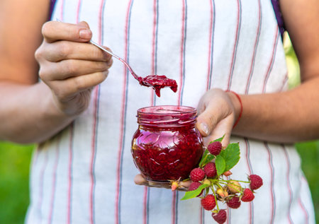 Raspberry jam in the hands of a woman. Selective focus.の写真素材