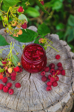 Raspberry jam in the garden. Selective focus.