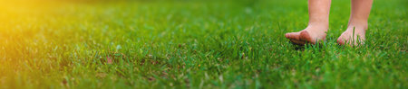 Child feet on the grass. Selective focus.の写真素材