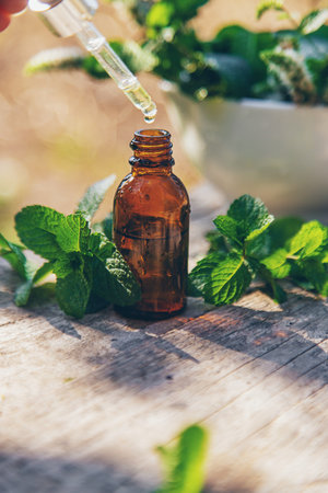 Peppermint essential oil in a bottle. selective focus.の写真素材