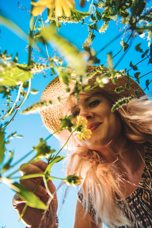 Woman in the park with flowers summer. Selective focus.の写真素材