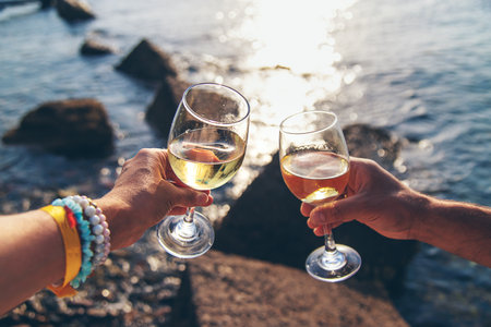 Glasses of wine on the seashore. Selective focus.の写真素材