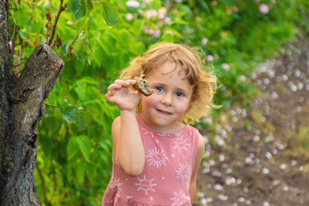 Child holding a snail on his hand. Selective focus.