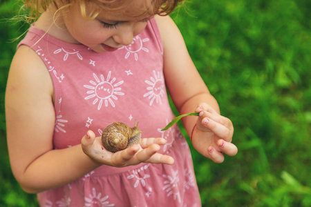Child holding a snail on his hand. Selective focus.の写真素材